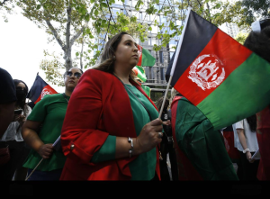 "An Afghan woman protests against the Taliban’s restrictive rules, holding a sign demanding freedom and rights. Her determined expression and the bold text on her sign highlight her stand against the oppression and injustice imposed by the Taliban regime."