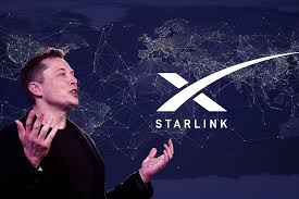 Elon Musk with a Starlink logo in the background, representing his satellite-based internet service aimed at providing global connectivity.