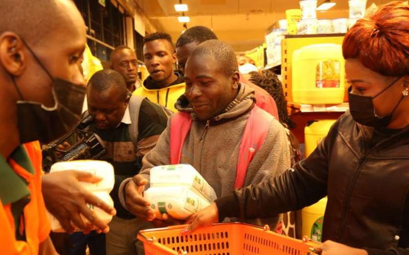 Customers paying at a supermarket counter with a cashier, illustrating the point-of-sale experience and how effective loyalty programs and customer service contribute to a positive shopping experience