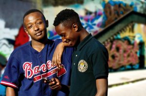 Two young men sharing festive content on their smartphones, engaged in social media during the holiday season.